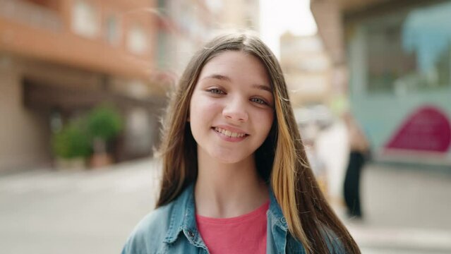 Adorable girl smiling confident looking to the camera at street