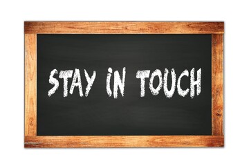 Obraz premium STAY IN TOUCH text written on wooden frame school blackboard.