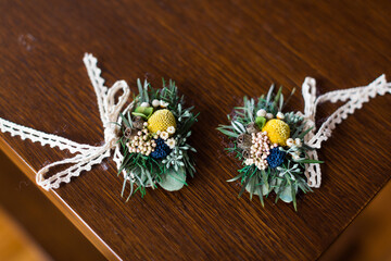 Pair of wedding boutonnieres on a wooden table