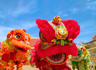 Three colorful Chinese Lions dance street performances celebration against blue sky in outdoor area