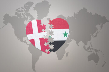 Fototapeta premium puzzle heart with the national flag of syria and denmark on a world map background. Concept.