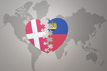 puzzle heart with the national flag of liechtenstein and denmark on a world map background. Concept.