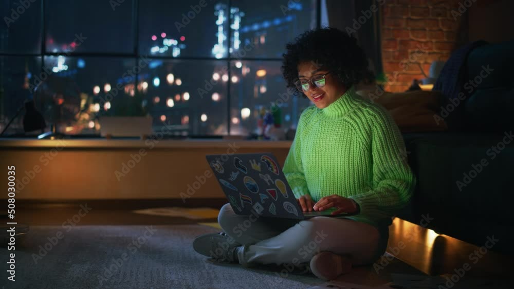Poster beautiful authentic latina female sitting at the floor in a cozy living room and using laptop comput