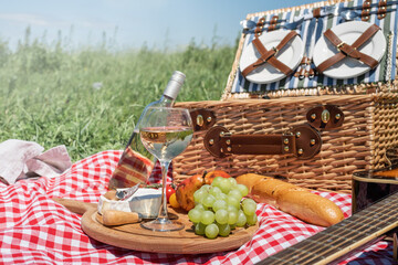 Closeup of picnic basket with drinks and food on the grass