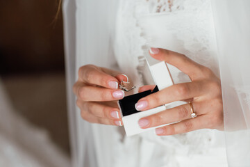 The bride holds a box with wedding rings