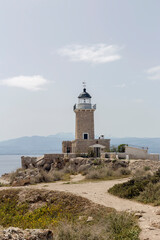 Fototapeta na wymiar Old, stone lighthouse against the backdrop of the sea and mountains