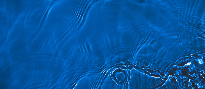 Transparent dark blue clear water surface texture with ripples and splashes. Abstract summer banner background Water waves with copy space, top view Cosmetic moisturizer micellar toner emulsion