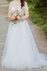 Fototapeta na wymiar Wedding dress for a summer wedding. Beautiful bridal bouquet