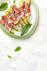 Appetizer with pear, blue cheese and prosciutto ham, Healthy fats, clean eating for weight loss, Restaurant menu, dieting, cookbook recipe vertical image. top view. place for text