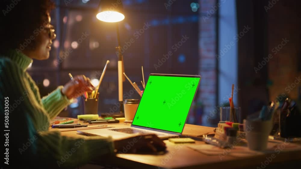 Fototapete Black Female Creator Zoom On and Zoom Out with Computer Mouse while Modeling on Laptop Computer with Green Chroma Key Screen. Freelance Woman Working at her Project