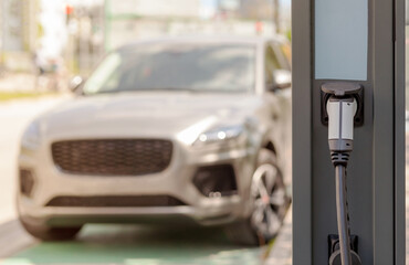 Electric car at Сharging station. E-charging slot on vehicle background. EV Car with the power...