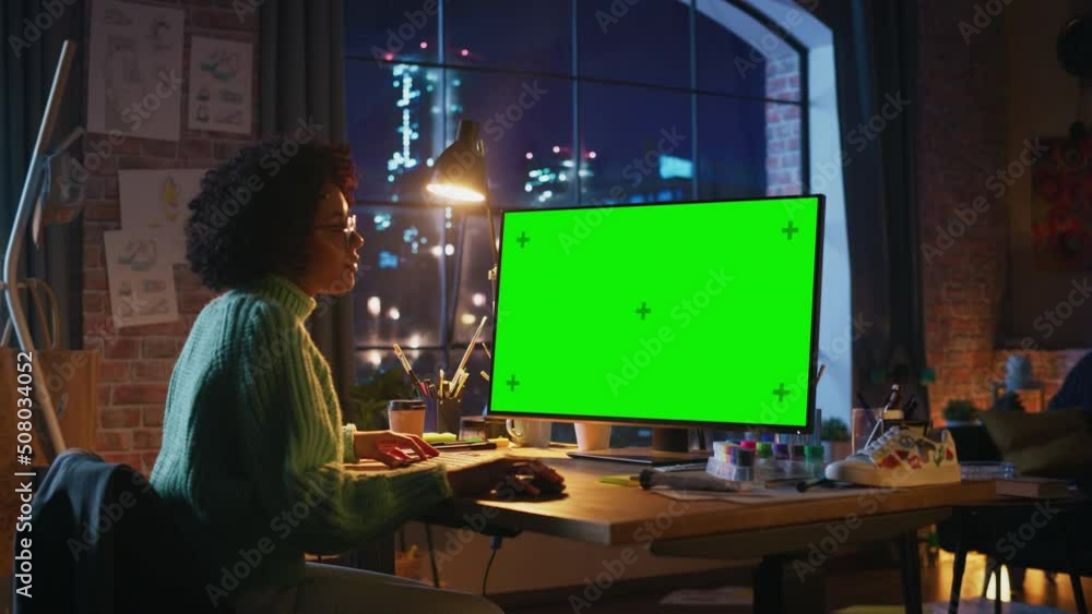 Fototapete latin professional female freelancer working on desktop computer with green chromakey screen and loo