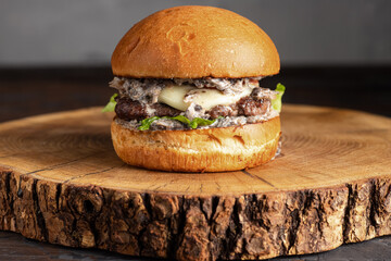 burger with meat, burger on a wooden table, juicy burger with different fillings