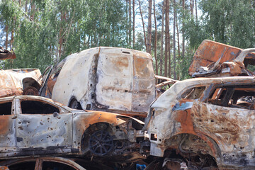 Fototapeta na wymiar car graveyard. Burnt and blown up car. Cars damaged after shelling from russian invasion. War between Russia and Ukraine. Terror attack bomb shell. Disaster area irpin bucha