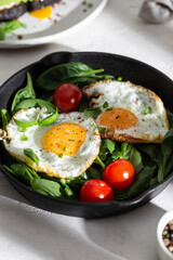 Breakfast with fried eggs and vegetables in a pan