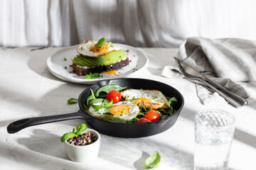 Breakfast with fried eggs and vegetables in a pan