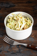 Cabbage salad, cabbage salad with dressing on a wooden background