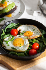 Breakfast with fried eggs and vegetables in a pan