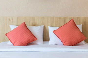 Fototapeta na wymiar Double red and white pillows on a wooden bed