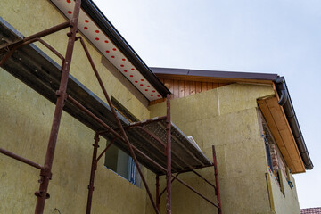 Fototapeta na wymiar Layer of thermal insulation on the wall of the house outside. Mineral wool panels.