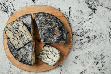 Asiago italian cheese with cuttlefishink on a wooden board. banner, menu, recipe place for text,...