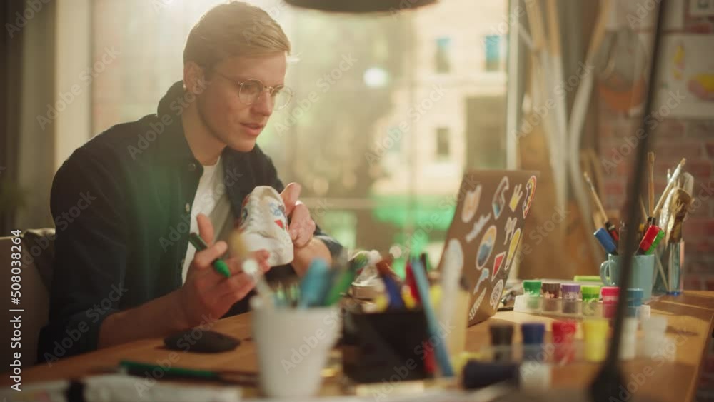 Leinwandbilder Up-and-Coming Designer Completes Work on a Unique Pair of Sneakers. Smiled Man Checks Result of Work with the Project on his Laptop. Breakthrough in Eco Design Concept