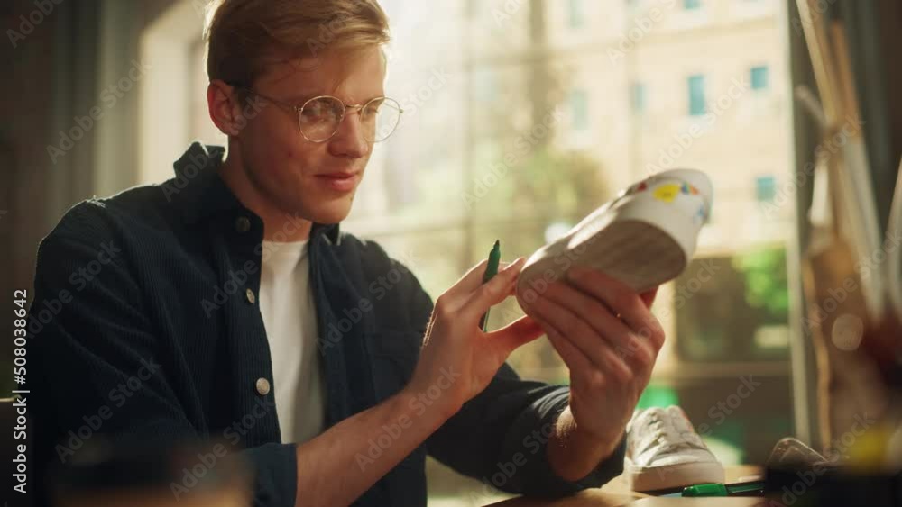 Aufkleber portrait view of the self-confident designer creating colourful brave design of shoes at his desk at