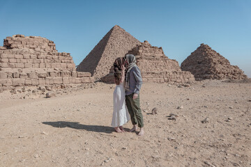 Couple in love wandering around the pyramids of Giza in Caïro.