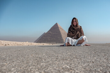 Woman sitting near the pyramids in Egypt.
