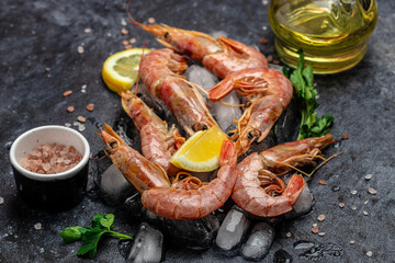 Red Argentine shrimps with ice and lemon, Wild shrimps, ocean jumbo shrimps on a dark background. Restaurant menu, dieting, cookbook recipe top view