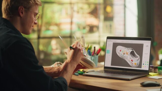 Inspired Blonde Man Creating Custom Made Model of Shoes while Look at 3D Prototype at his Laptop. Art and DIY Objects Concept. Over the Shoulder