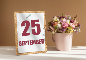 september 25. 25th day of month, calendar date.Bouquet of dead wood in pink mug on desktop.Cork...