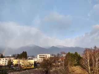 Fototapeta premium Rainbow in the city over eht hills and houses. Slovakia