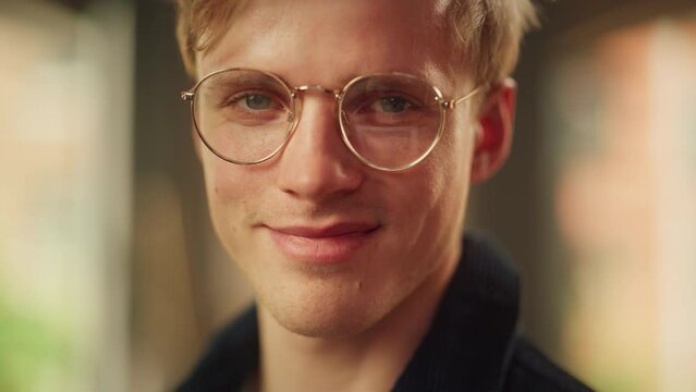 Cinematic Shot of Blonde Male Digital Entrepreneur in Glasses Standing at Home, Looking at the Camera with Smile. Man Contemplating e-Business Ideas, Investment Strategy. Close Up