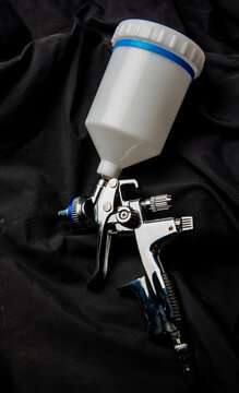 Paint spray on background floors Image of the painter's arm hand holding industrial size spray gun used for industrial painting and coating and isolated on background clipingpart