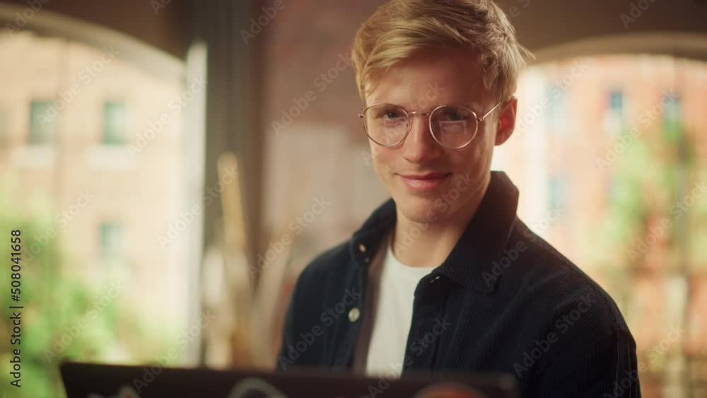 Poster portrait of a handsome man working from home on laptop computer in stylish loft apartment. creative 