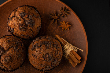 Chocolate cupcakes on a brown plate. Homemade fluffy chocolate cupcakes. Cupcakes with chocolate and cinnamon