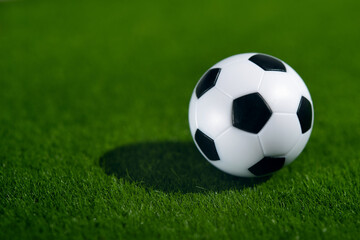 Fototapeta na wymiar One football soccer ball on a green grass field
