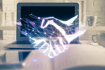 Desktop computer background in office and handshake hologram drawing. Double exposure. Pertnership concept.