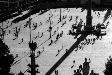 pedestrians are walking throught a square