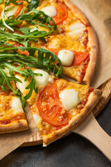 Pizza margarita with green fresh arugula salad