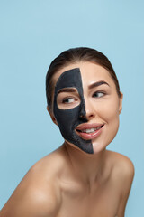 Beautiful young woman with mask for the face of black clay on clean fresh skin . Girl model beauty face care with  cosmetic mask. Facial treatment . Skin care