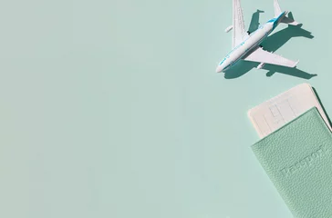Küchenrückwand glas motiv Flugzeug mit Reisepass und Tickets auf dem hellen sonnigen blauen Hintergrund. Reisekonzept für Sommerferien. © mariarom