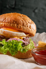 Fat Burger with egg and cutlet in restaurant on table