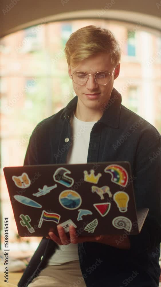 Leinwandbilder vertical portrait of a handsome man working from home on laptop computer. creative male browsing int