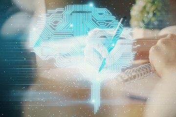 Multi exposure of writing hand on background with brain hologram. Concept of self learning.