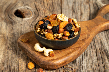 Mixed nuts on wooden background. Nuts, walnuts, raisins and cashews. close up