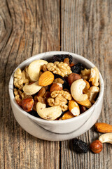 Mixed nuts on wooden background. Nuts, walnuts, raisins and cashews. close up