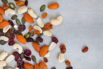 trail mix with nuts and cranberries on rustic grunge background with copy space