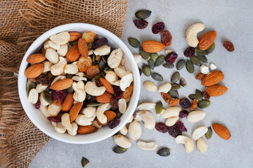 trail mix with nuts and cranberries on rustic grunge background with copy space
